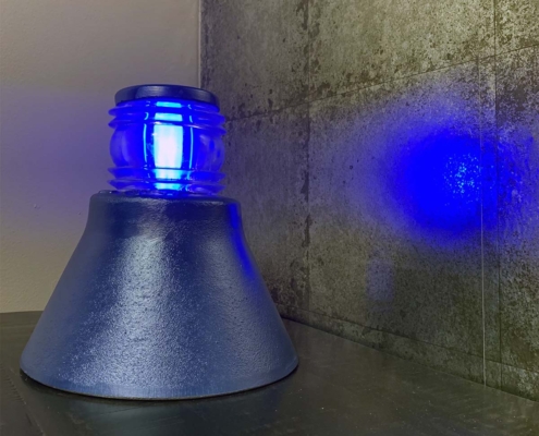 Refurbished Koninklijke Luchtmacht taxiway light with the blue light reflecting on the wall.