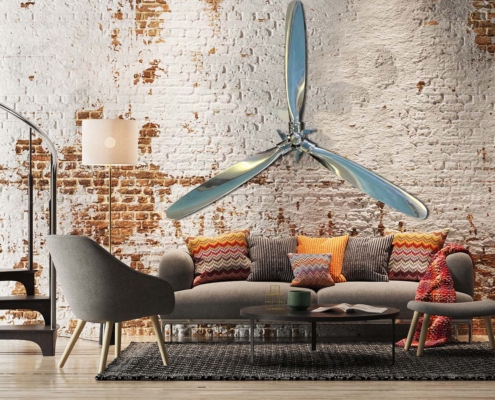 Polished Hartzell propellers and hub hanging on a brick wall in an industrial style living room.