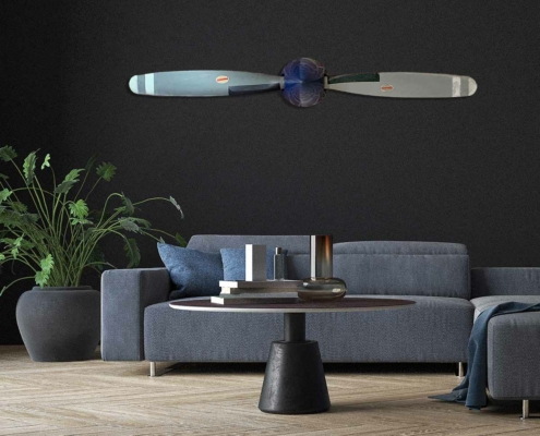 Two-bladed Hartzell propeller with spinner in original colours, mounted on a wall in a modern living room.