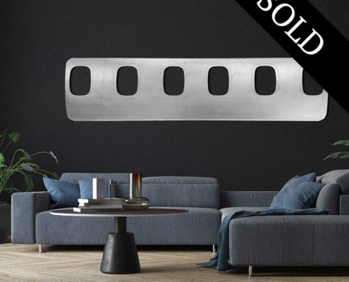 Six-window panel of an ATR passenger aircraft turned into a decorative piece and hanging in a modern living room.