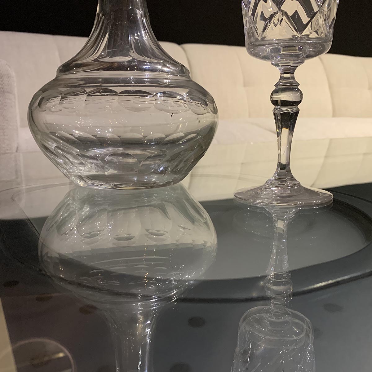 Crystal vase and wine glass on a coffee table.